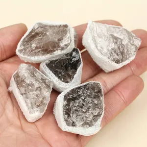 Handheld view of raw natural smokey quartz crystals with irregular rough textures