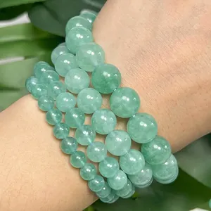 Close-up of green angelite stone beads in various sizes on a wrist for DIY jewelry