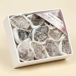Detailed macro view of raw smokey quartz mineral stones inside white gift box display