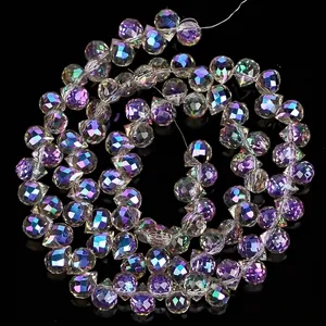 Detailed view of 6mm faceted iridescent crystal water drop beads with magenta and green tones