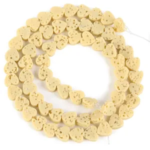 Detail view of cream heart-shaped porous volcanic stone beads for DIY jewelry making
