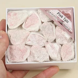 A white decorative gift box containing natural raw pink talc mineral stone specimens