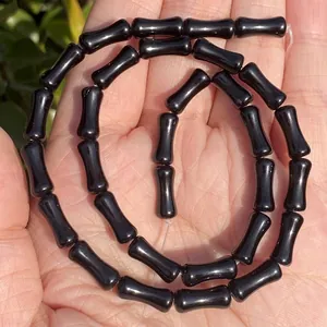 Macro view of highly polished 5x12mm black onyx bamboo-joint shaped beads for DIY jewelry making
