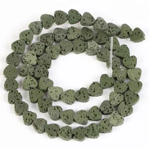 Close-up of heart-shaped green volcanic lava stone beads with porous texture for DIY jewelry
