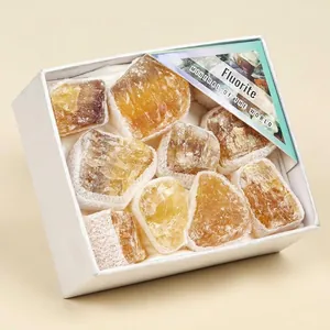 Nahaufnahme von natürlichen gelben Fluorit-Rohsteinen in einer weißen Geschenkbox