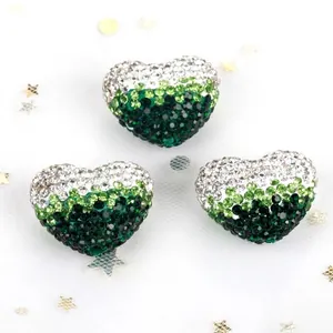 Detailed macro shot of gradient green and white heart-shaped rhinestone beads for DIY jewelry