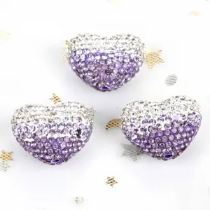 Macro view of gradient purple heart-shaped rhinestone disco beads for DIY jewelry crafts