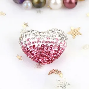 Close-up detail of gradient pink and white rhinestone encrusted heart-shaped bead charm
