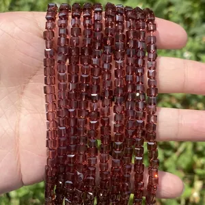 Detailed view of faceted dark red square glass beads for DIY jewelry making.
