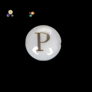 Detaillierte Nahaufnahme einer runden Perlmuttperle mit einer goldfarbenen P-Gravur.