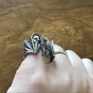Detailed macro view of a vintage punk dragon ring with silver finish worn on a finger
