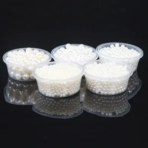 Detailed view of various sizes of white ABS round faux pearls with double holes for DIY crafts.