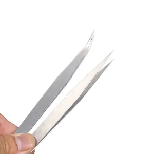 Primer plano de pinzas de acero inoxidable plateado rectas y curvas para joyería