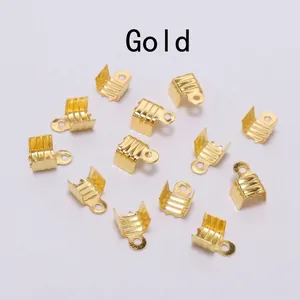 High-definition detail view of shiny gold metal cord end crimps for DIY jewelry making.