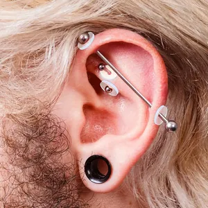 Close-up detail of soft silicone piercing discs for earring studs on a human ear