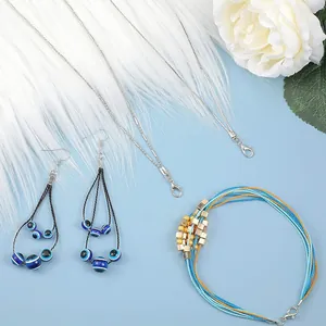 Handmade jewelry set featuring blue evil eye earrings and colorful corded bracelet