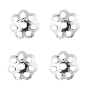 Macro view of four 6mm silver hollow daisy flower bead caps for DIY jewelry crafts
