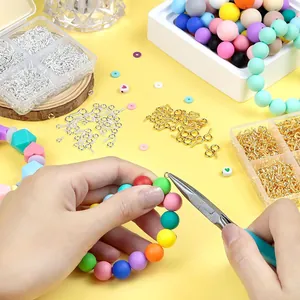Close-up of DIY jewelry making with colorful silicone beads and metal eye pins hooks.