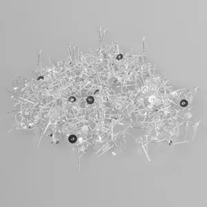 Macro detail view of a bulk pile of silver earring posts for DIY jewelry making