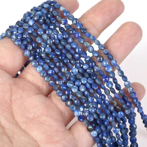 Detailed view of 4mm faceted blue stone disc beads held in hand for DIY jewelry making