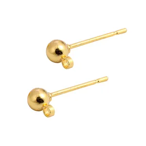 Macro detail of golden ball stud earring posts with integrated hanging loops