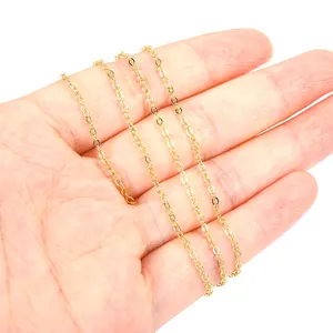 Detailed macro view of an 18K gold-plated O-cross chain necklace on hand
