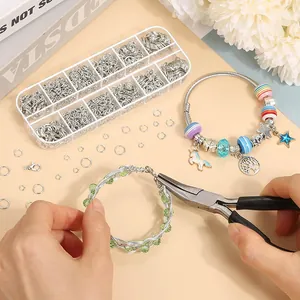 Detalle de manos usando alicates para montar un kit de pulseras de bricolaje DIY.
