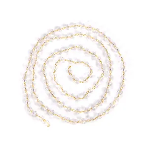 Close-up detail of a spiral coiled 18K gold plated copper chain with clear faceted beads