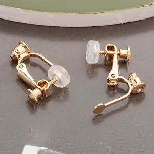 Macro detail of gold-finish screw-back earring converters with clear silicone pads