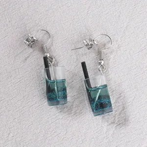 Detailansicht kreativer Miniatur-Ohrringe in blauer Becherform mit Glitzer und Silberhaken
