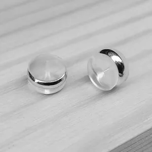 Detailed macro view of clear silicone hamburger earring backs with silver metallic bands.