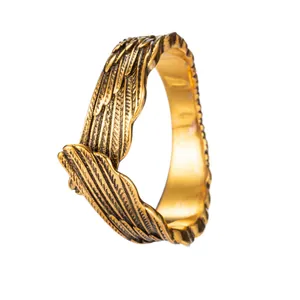 Macro detail of vintage copper angel wing ring with intricate engraved feather texture