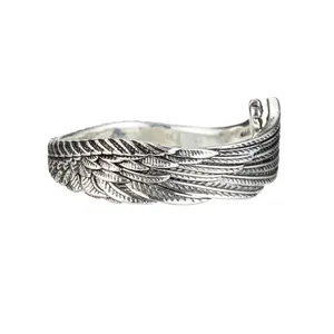 Close-up detail view of a vintage silver angel wing ring with intricate feather textures
