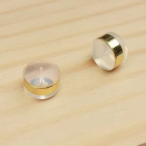 Close-up detail of clear silicone earring backs featuring gold-plated metal bands