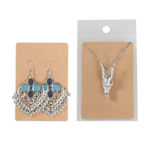 Detail view of bohemian heart earrings and dragon necklace on kraft paper cards