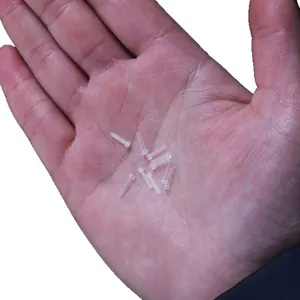Manchons d'oreille en plastique PC transparents pour bijoux DIY, présentés sur main.