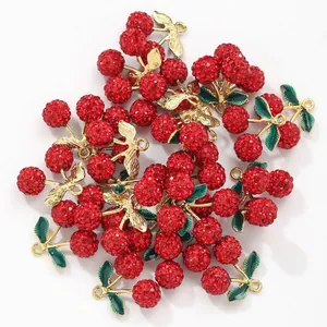 Detail von roten Strass-Kirsch-Anhängern mit Goldstiel und grünen Blättern für DIY