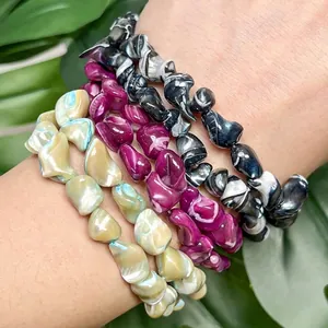 Close-up of 9-14mm multicolor irregular shell beads on wrist for DIY jewelry.