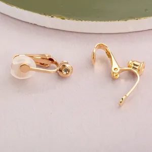 Close-up of gold-plated spring earring clip converters with silicone comfort pads.