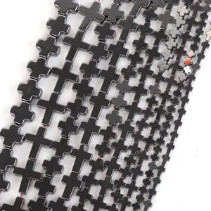 Close-up of metallic black hematite beads in cross shape for DIY jewelry making.