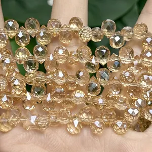 Detailed close-up of faceted amber strawberry crystal teardrop beads for jewelry making