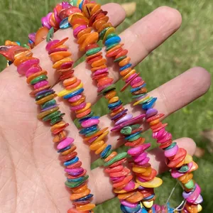 Close-up detail of Bohemian colorful shell chip beads in hand for DIY jewelry accessories