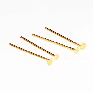 Detail macro view of four gold-tone metal T-pins for DIY jewelry and earring making