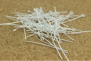 Close-up view of silver-plated 9-shaped eye pins for DIY jewelry making beading crafts