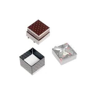 Small square gift boxes with polka dots stripes and silver bow on white background