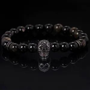 Close-up of a micro-paved skull charm centerpiece on an 8mm dark beaded bracelet