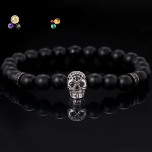 Macro view of 8mm matte black bead bracelet featuring a silver pavé skull charm