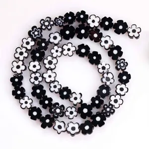 Macro view of 8mm black and white flat plum blossom lampwork beads for jewelry DIY
