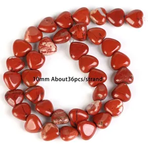 Macro detail view of 10mm heart-shaped red jasper stone beads for jewelry craft DIY projects