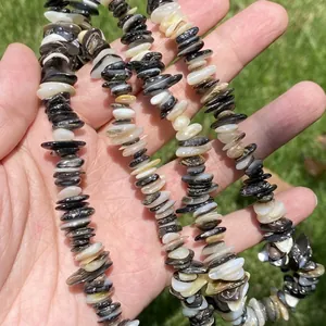 Close-up of irregular black and white shell stone beads for DIY jewelry making 38cm